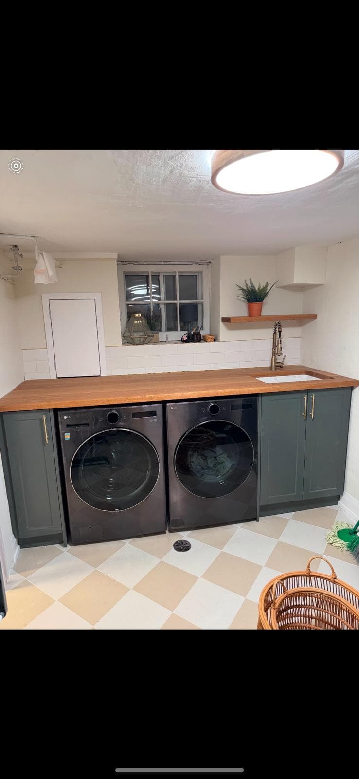 Custom basement laundry with butcher-block counter and dark shaker cabinets