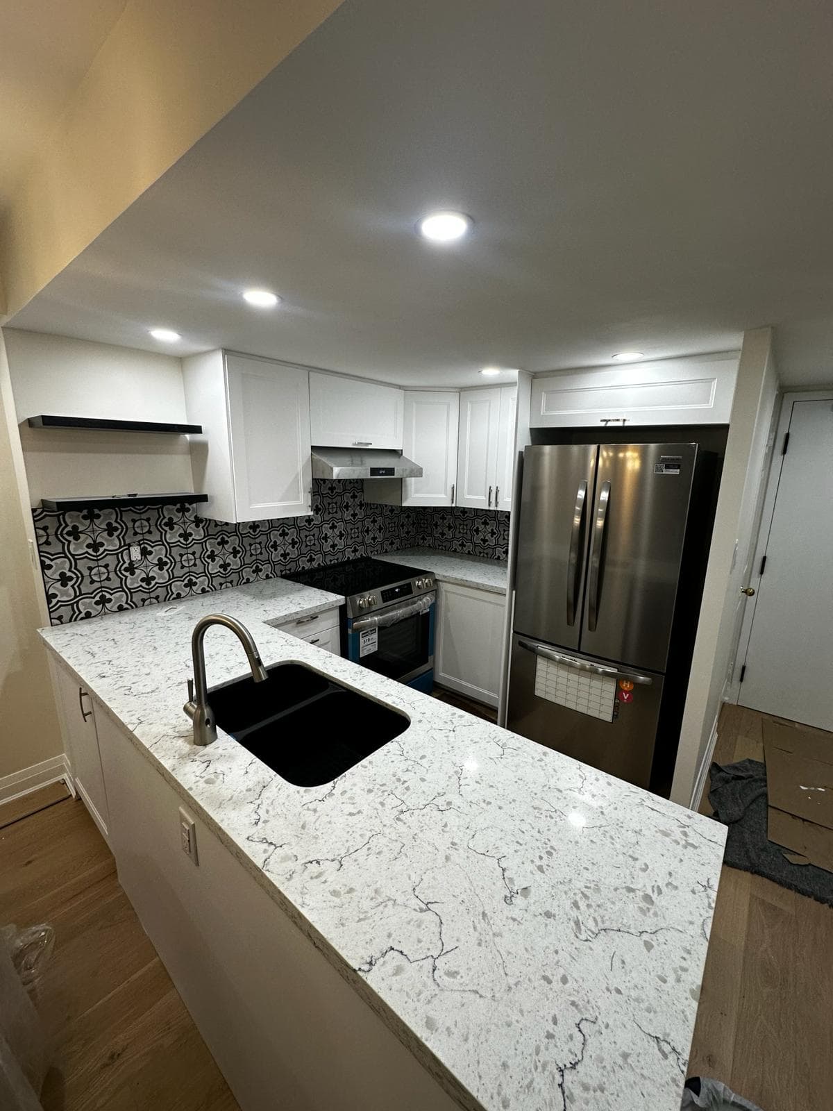 Etobicoke modern condo kitchen with patterned tile backsplash and white quartz counters
