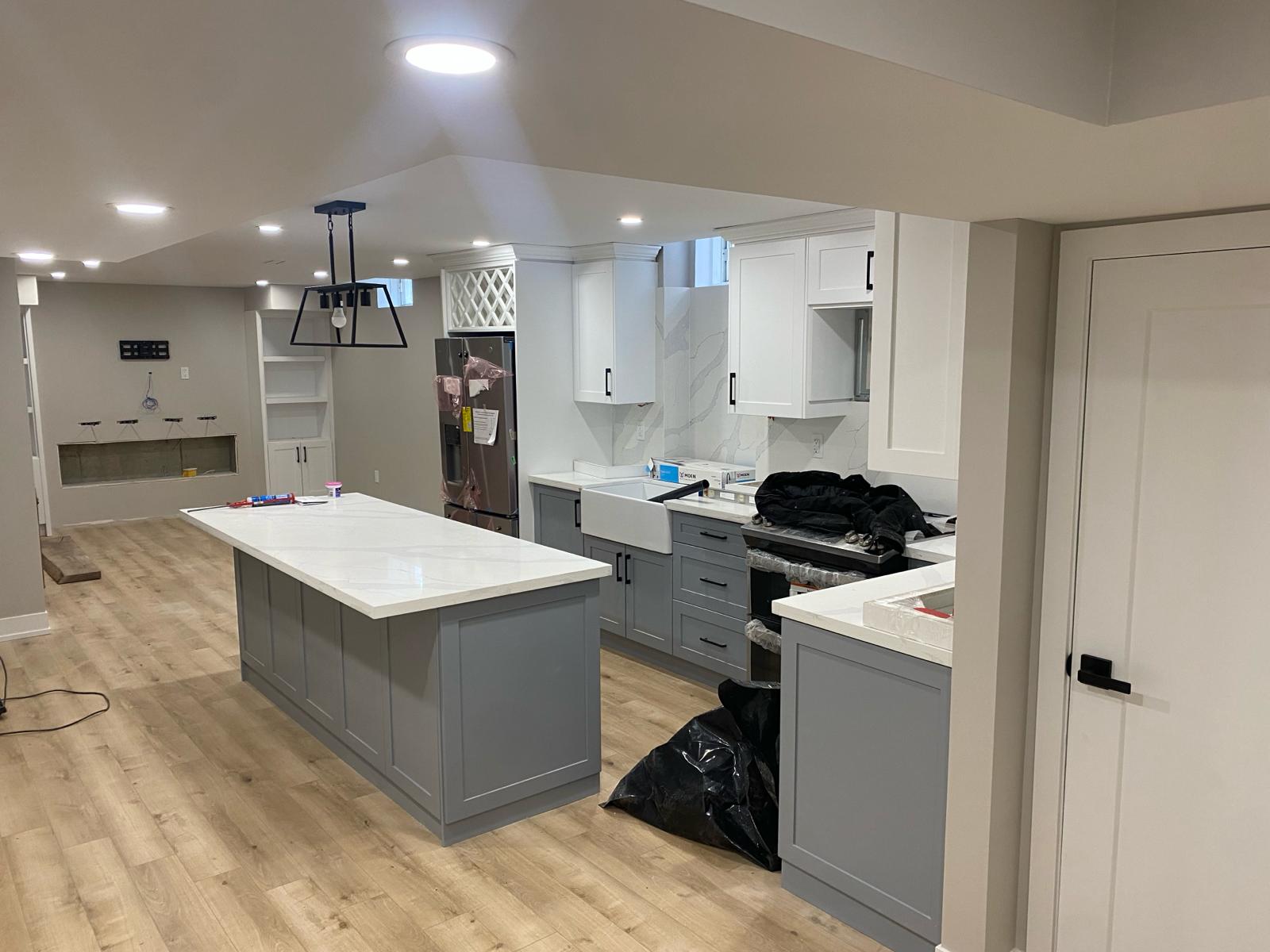 Toronto kitchen with marble waterfall island, grey shaker cabinets, and pendant cluster